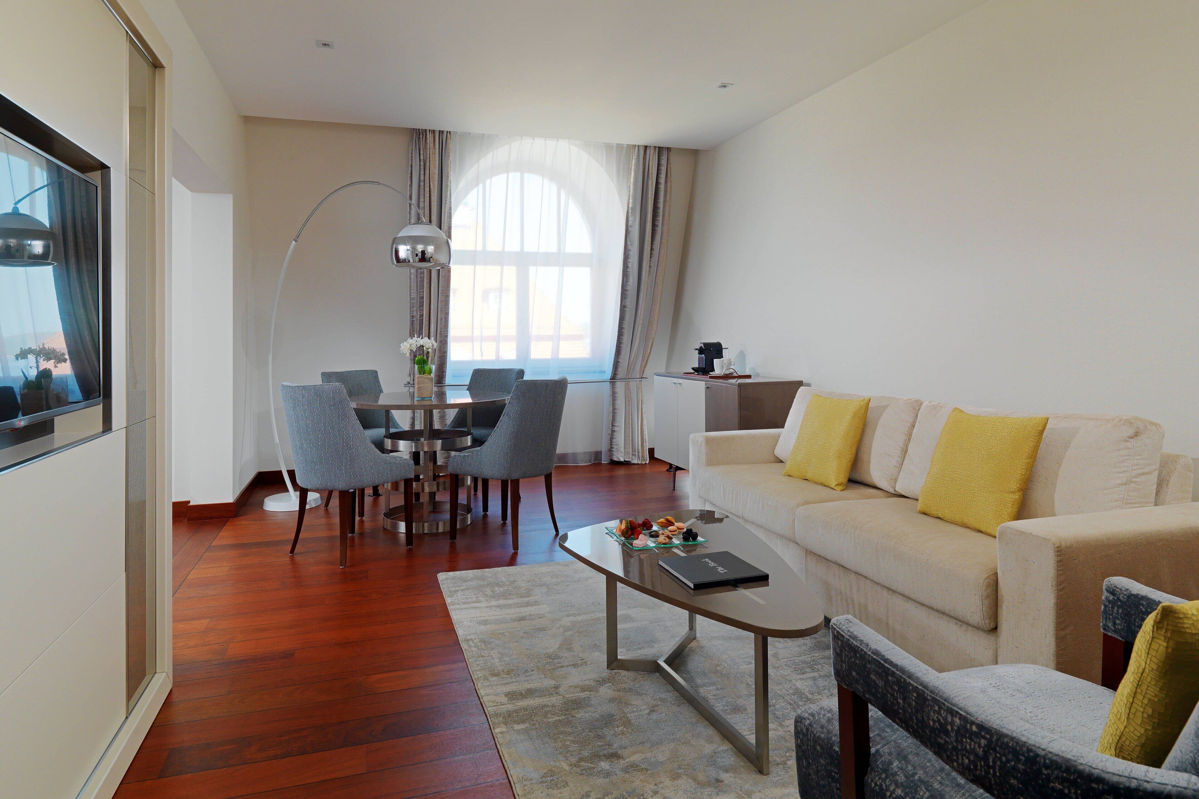 Uma sala moderna com sofá, mesa de centro e área de jantar.