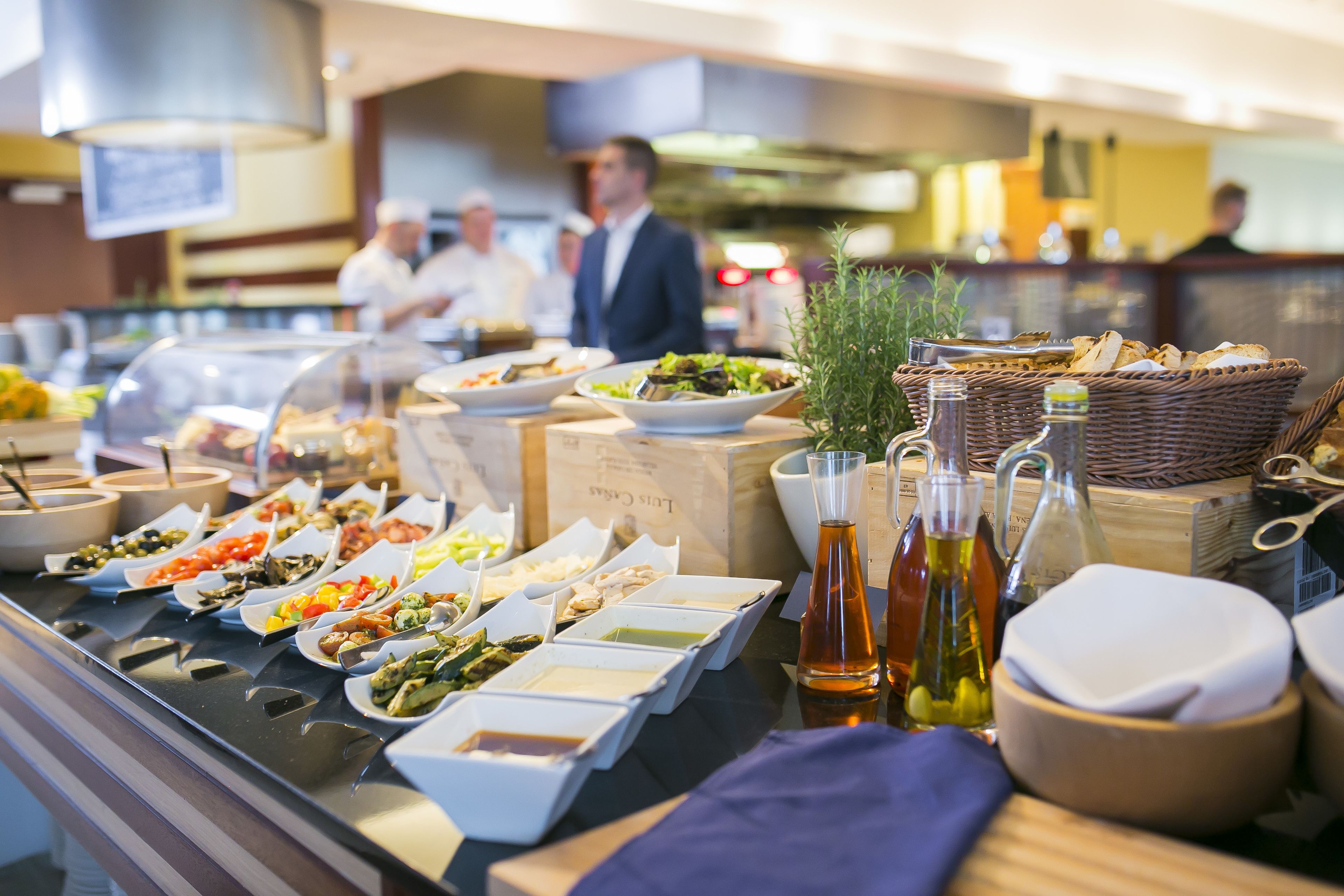 A buffet with various dishes and condiments.