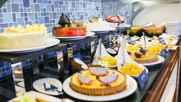 Un bufé con diversos postres y frutas.