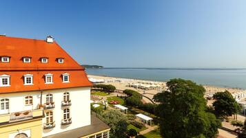 Een kusthotel met een rood pannendak, een zichtbaar casino bord en uitzicht op het strand.