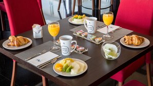 A breakfast table with croissants, fruit, juice, and a coffee mug. - Hotel Eurostars Rey Fernando (Zaragoza)