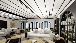 A modern living room with a sofa, coffee table, and chairs, a bookshelf, and large windows with arched tops.