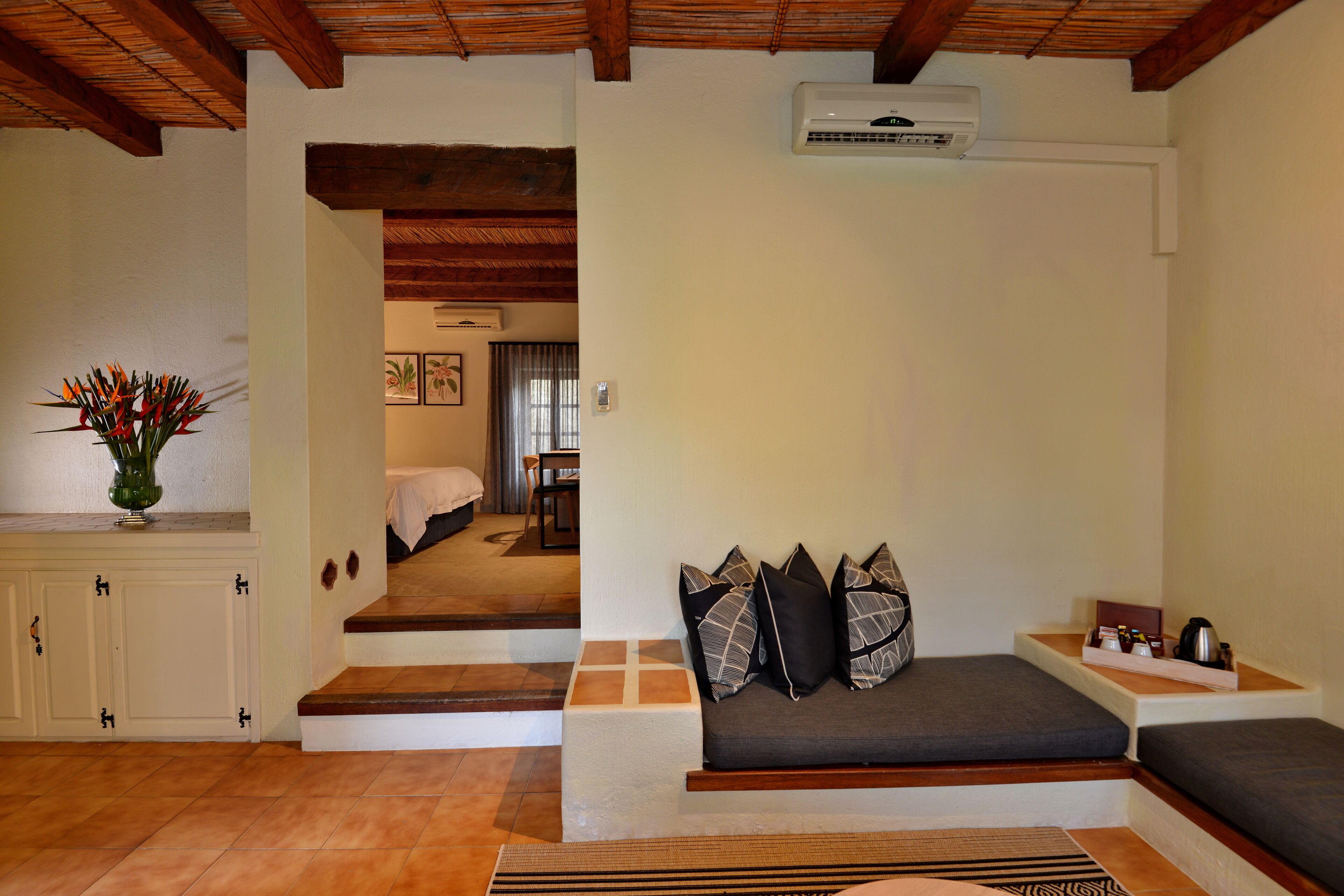 A cozy room with a sofa, a small table, and a staircase leading to another room.