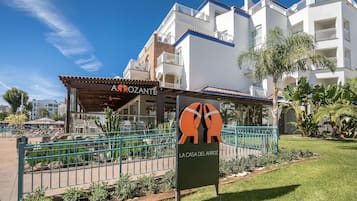 Un hotel con fachada blanca, balcones y un letrero que dice "LA CASA DEL ARROZ".