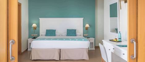 A bedroom with a bed, bedside tables, a desk, and a chair.