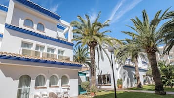 Guests can relax in the hotel's courtyard, surrounded by palm trees and a well-maintained lawn.