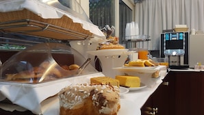 A buffet with various food items, including pastries and a coffee machine. - Hotel Best Roma (Rome)