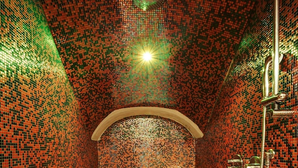 A bathroom with mosaic tile walls, a bathtub, a shower, and a candle. - Hotel Best Roma (Rome)