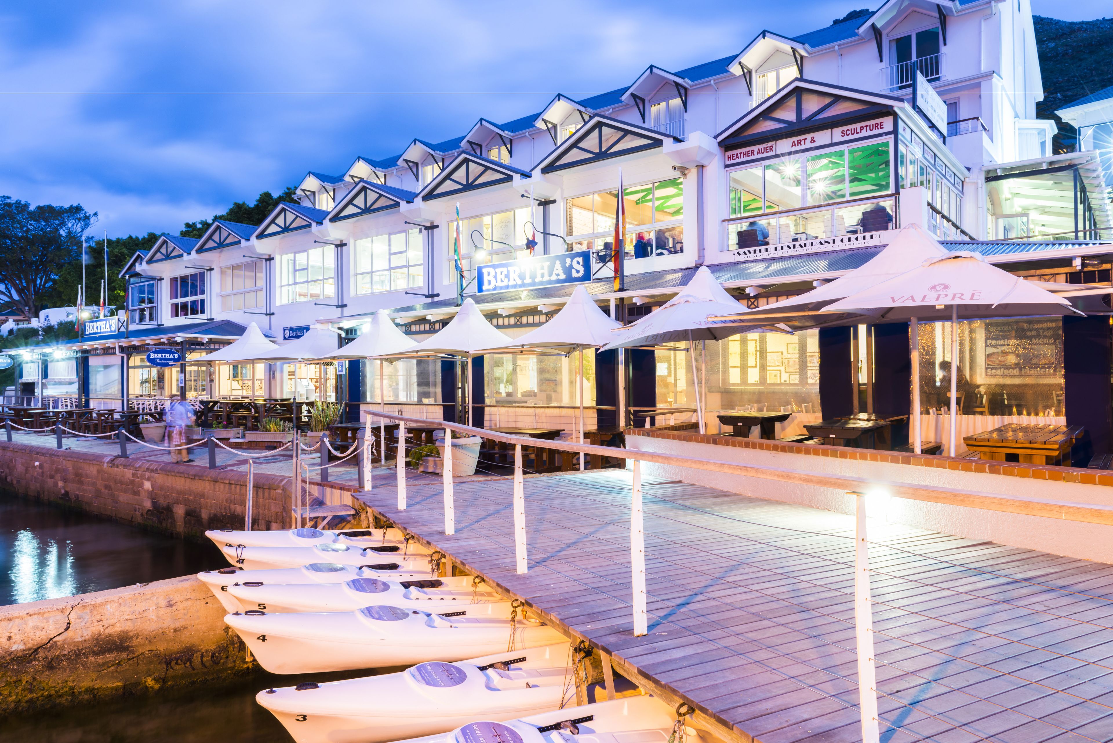 A waterfront hotel with multiple dining areas and a dock with kayaks.