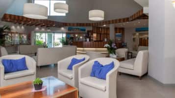 Eine geräumige Lobby mit einer Rezeption, mehreren Sitzbereichen und einem großen Fenster, das für natürliches Licht sorgt.