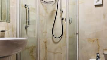 A modern bathroom with a glass-enclosed shower, a sink, and a bidet.