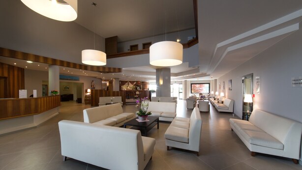 A spacious lobby with multiple seating areas, a reception desk, and a bar/lounge area.