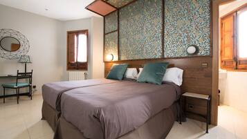 Un dormitorio con una cama grande, un escritorio y una silla.
