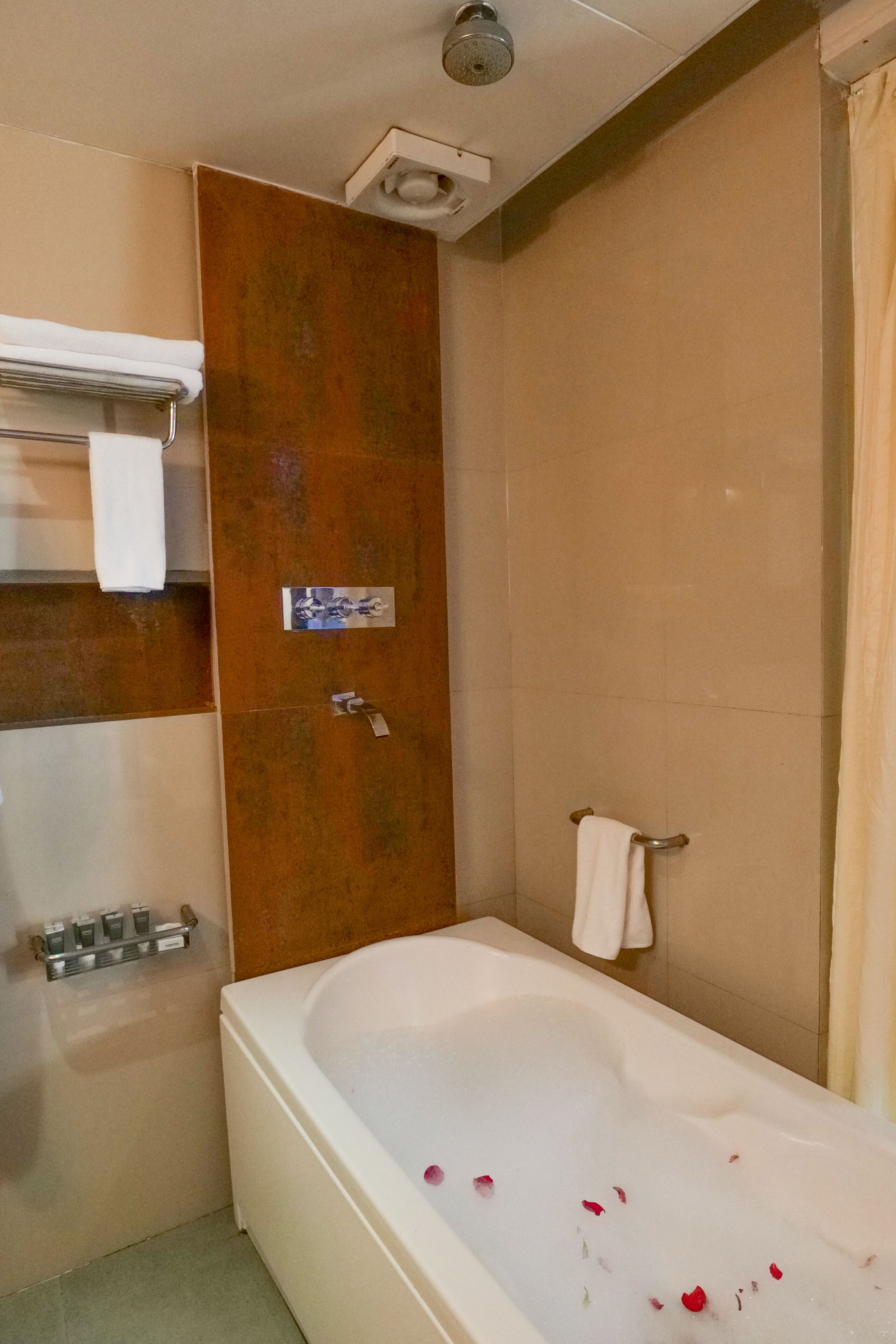 Une salle de bain avec une baignoire, un porte-serviettes et un rideau de douche.