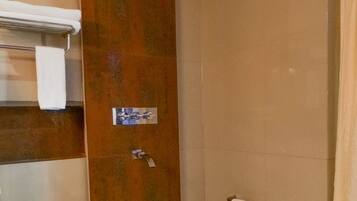 Un baño con bañera, toallero y cortina de ducha.