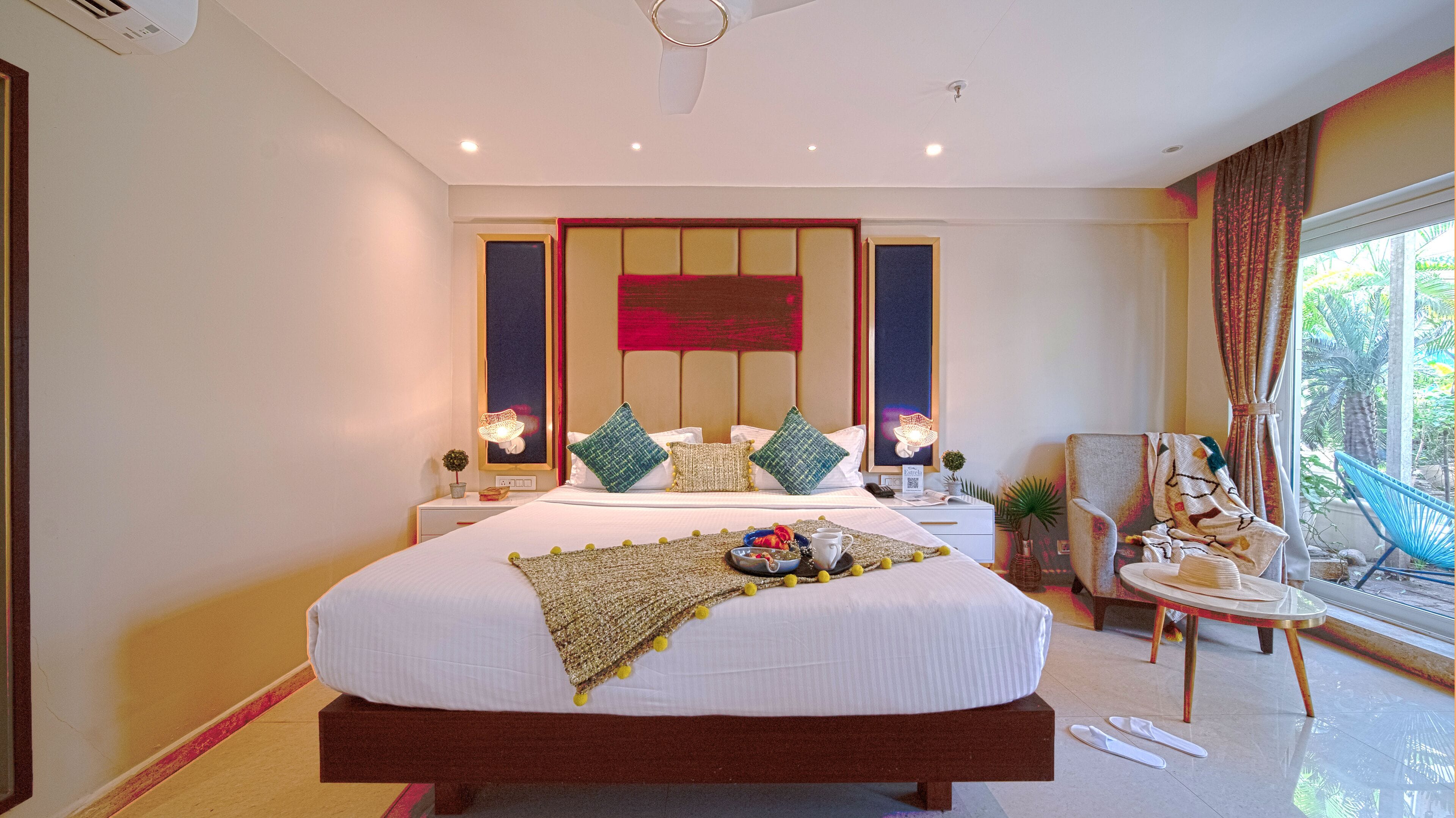 Een ruime slaapkamer met een groot bed, nachtkastje, stoel en uitzicht op de omgeving.