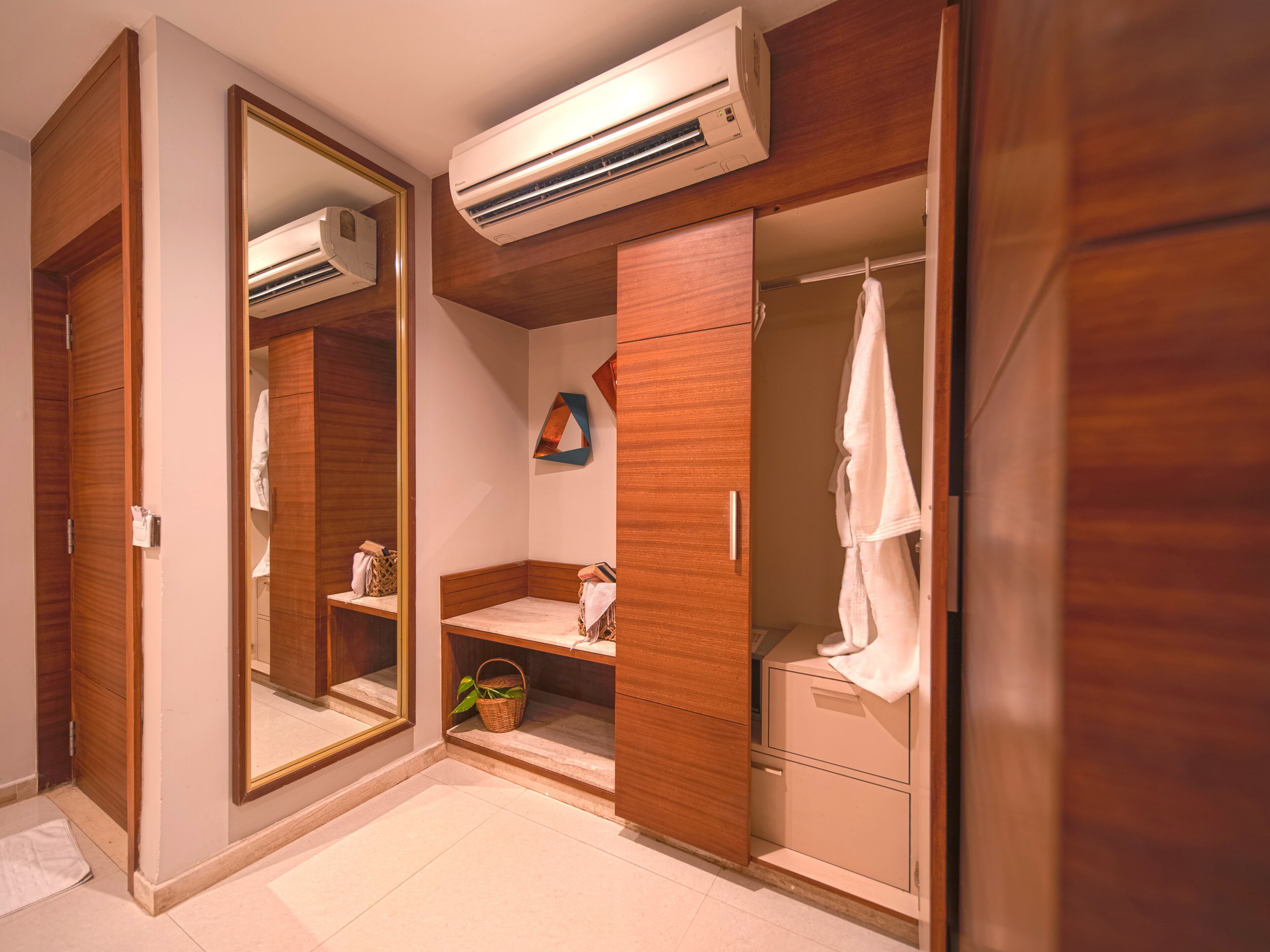 A walk-in closet with wooden doors, a mirrored section, and an air conditioning unit above.