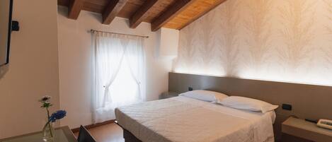 Een slaapkamer met een bed, nachtkastje en een bedtafel.