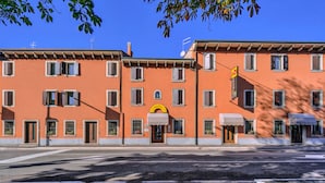 Un hotel con un letrero de arco amarillo, varias ventanas y vista a la calle.