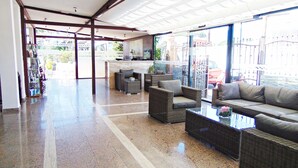 A spacious lobby with a polished floor, wicker furniture, and a glass partition. - Hotel Campomar Playa (El Puerto de Santa Maria)