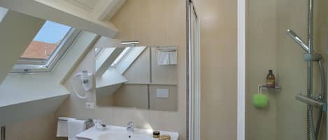 Un baño moderno con tragaluz, un lavabo, un espejo y una ducha.