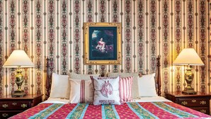 A bed with a patterned quilt, a pillow with 'Walker Farms' text, and a framed painting above. - Waynebrook Inn, Est 1865 (Honey Brook)