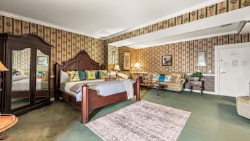 Ein traditionell eingerichtetes Schlafzimmer mit einem Himmelbett, einer Couch und einem kleinen Tisch.