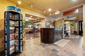 A reception area with a counter, a magazine rack, and a stone wall.