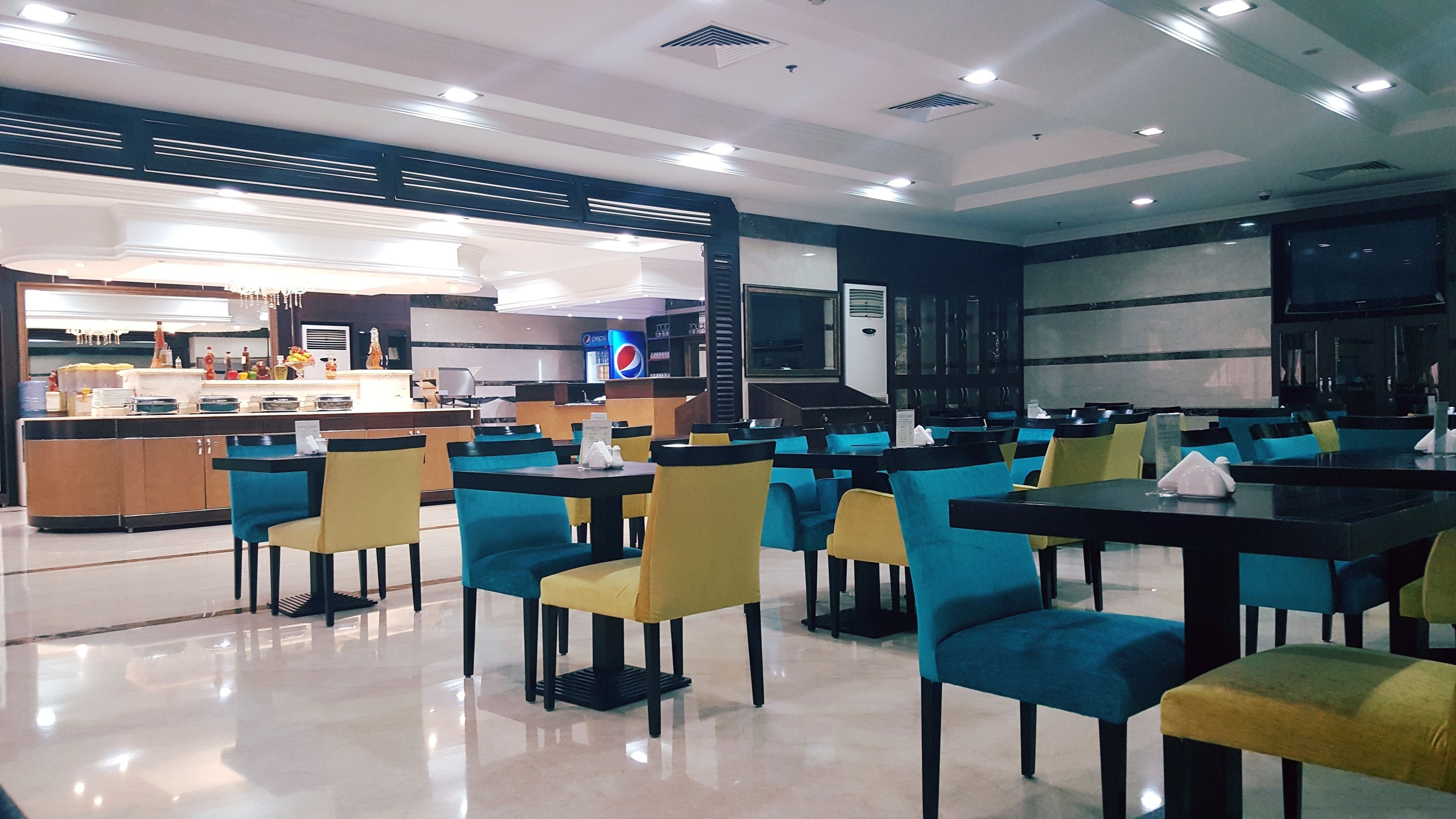 A modern restaurant with a clean, polished floor and a variety of seating options including tables and chairs.