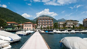 Un port de plaisance avec des bateaux amarrés, une jetée en bois et, au fond, des bâtiments dotés de balcons.