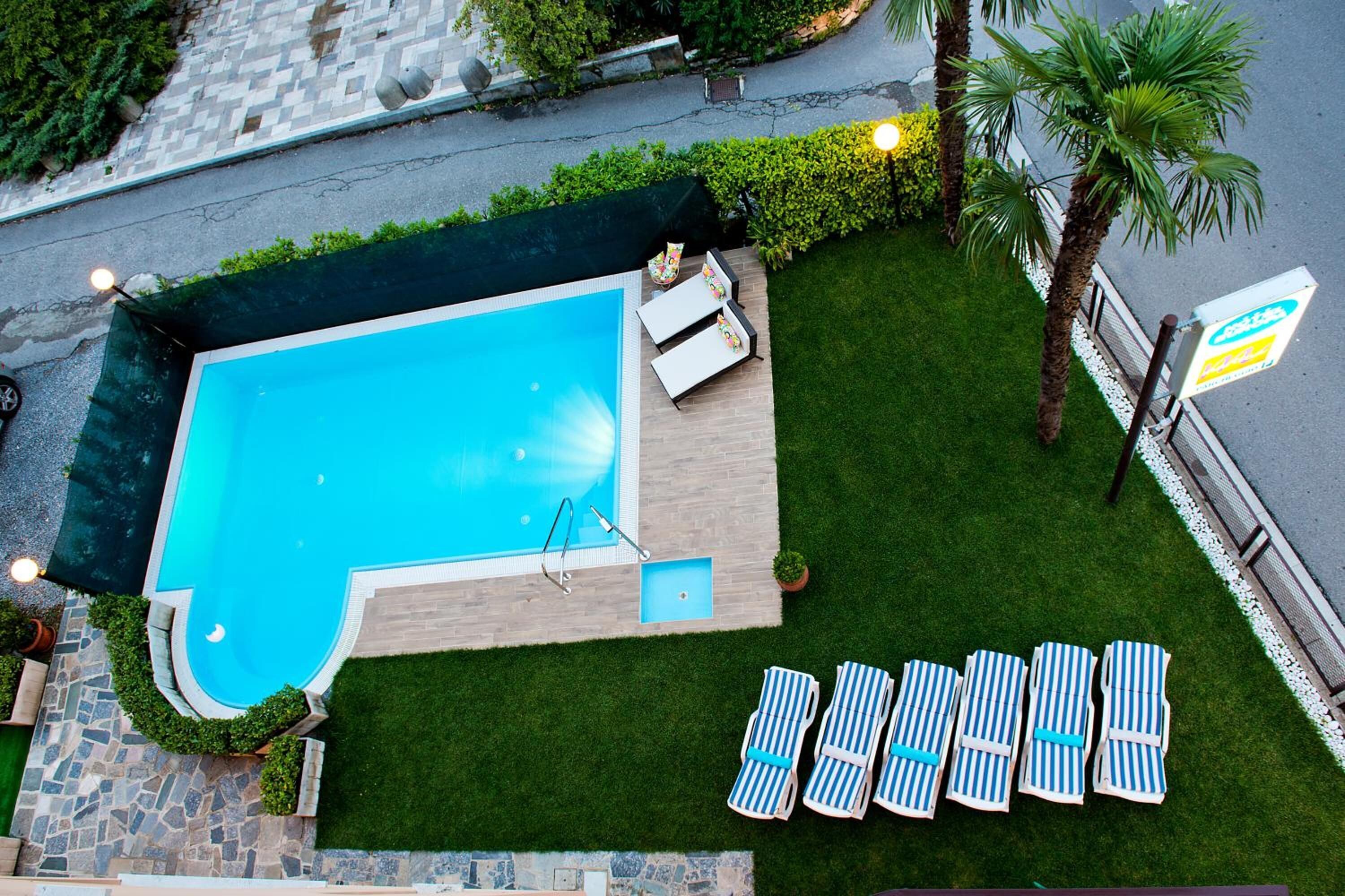 A swimming pool with lounge chairs and a small deck area.