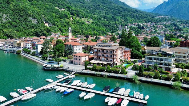 Un port de plaisance avec des bateaux amarrés, une promenade en bord de mer et des bâtiments dotés de balcons donnant sur l’eau.