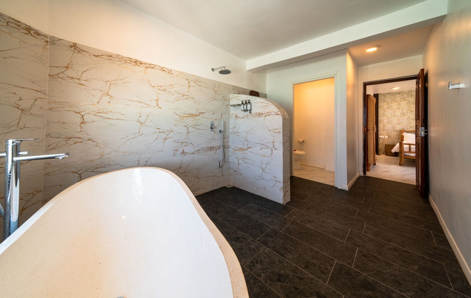 A modern bathroom with a freestanding bathtub, a shower area, and a toilet.
