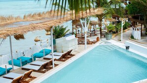 Un espace piscine avec des chaises longues et vue sur la mer.