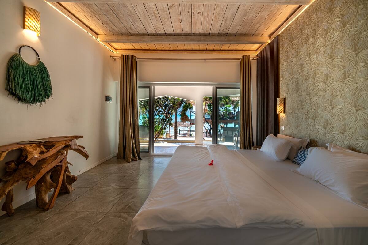 Une chambre spacieuse avec un grand lit, une table basse en bois et une vue sur l’extérieur.