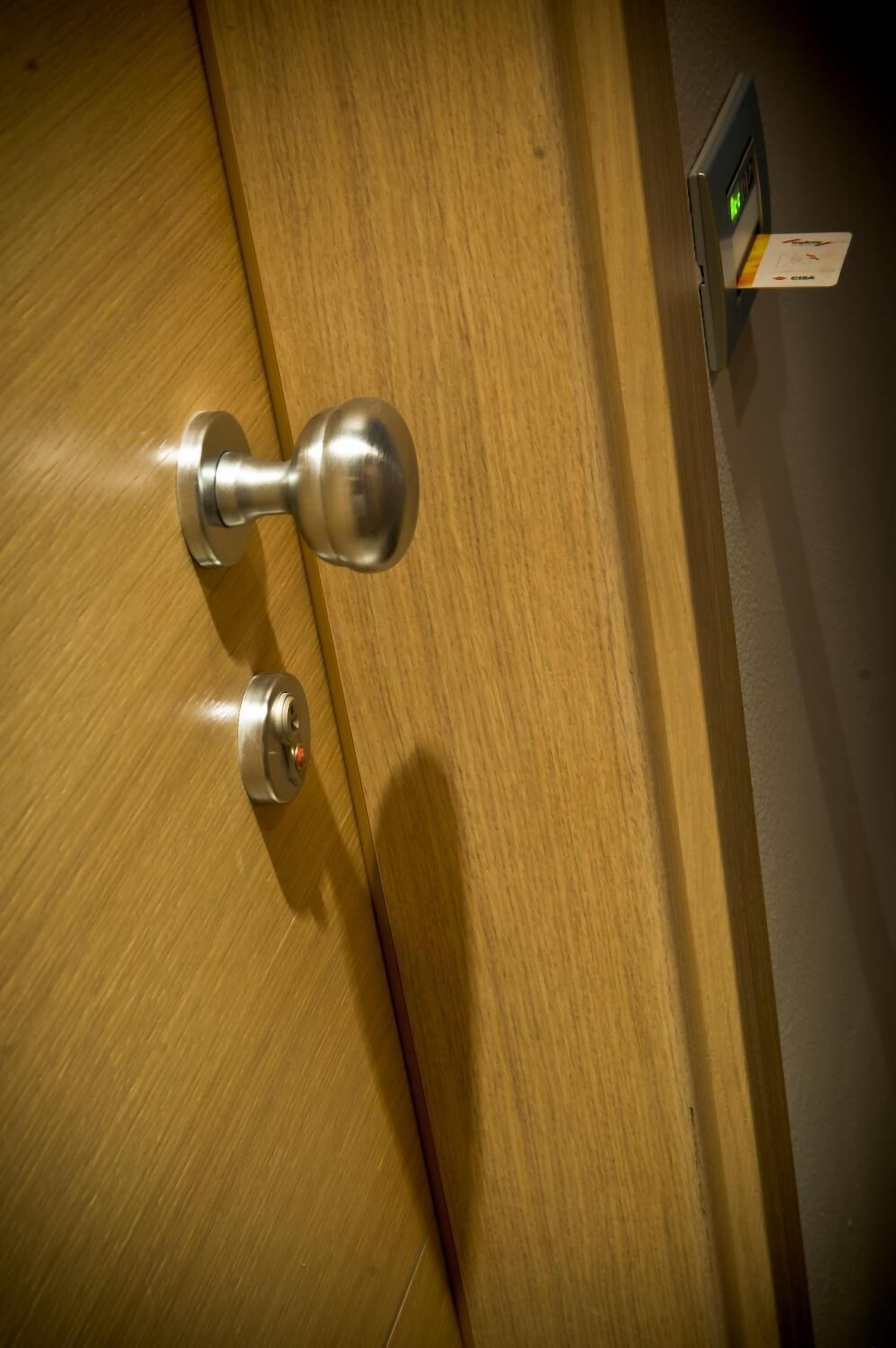 A wooden door with a silver doorknob and a digital lock.