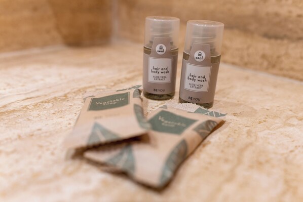 Two bottles of hair and body wash on a textured surface. - Hotel Tivoli (Tivoli)