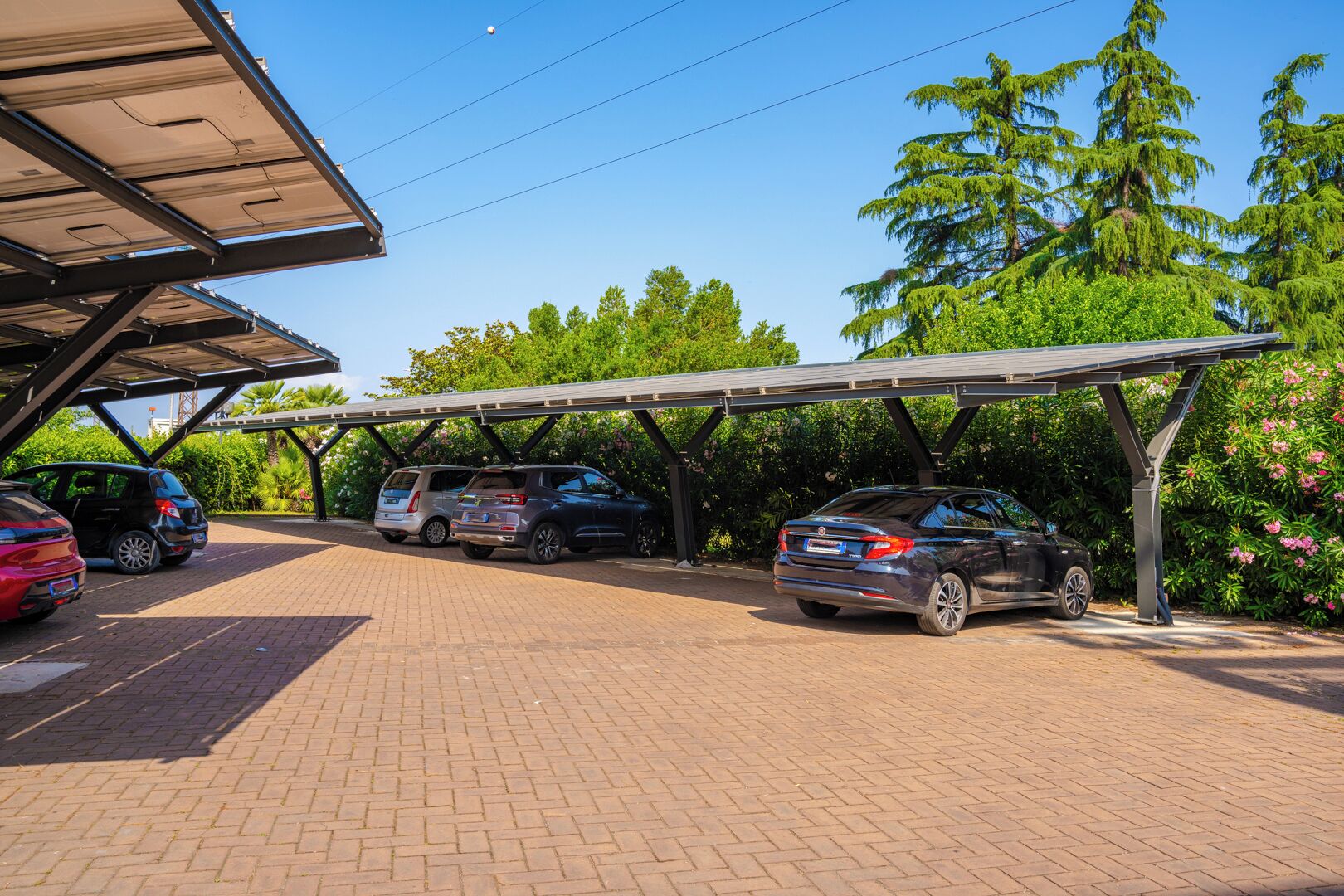 Un área de estacionamiento techada con varios coches aparcados bajo una estructura.
