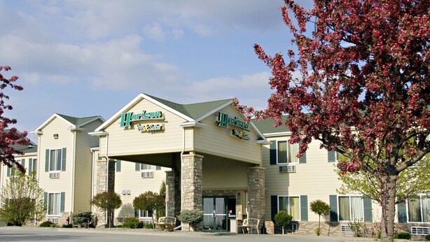 A hotel with a sign reading "Horizon Inn & Suites" featuring a stone facade and a covered entrance.