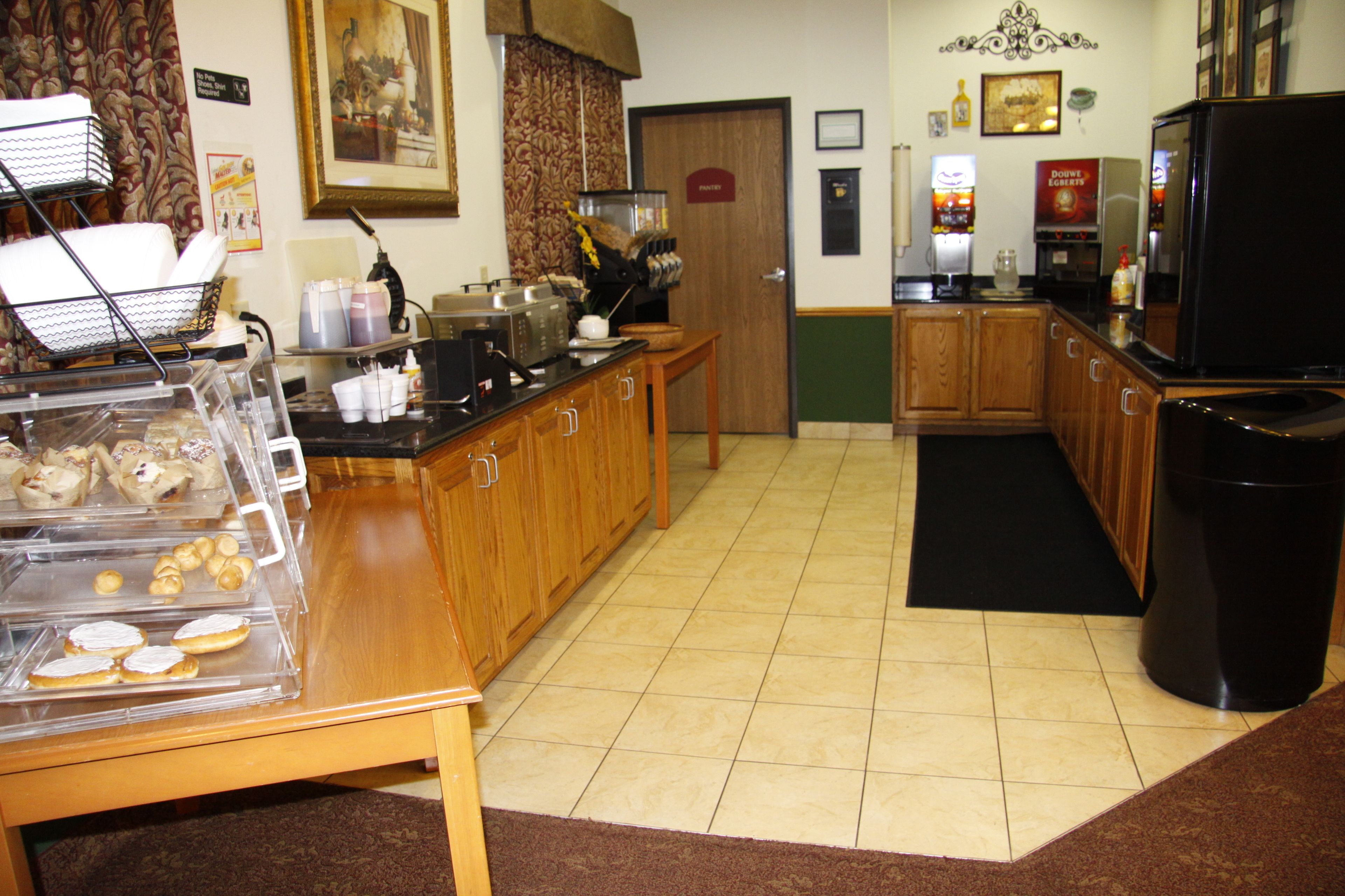 A kitchen with a coffee station, a refrigerator, and a door labeled "Pavement."