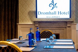 A conference table at Dromhall Hotel Killarney with blue water bottles, glasses, and name cards.