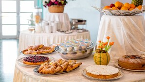 A buffet table with various pastries, a fruit basket, and a floral centerpiece. - Victoria Terme Hotel (Tivoli)