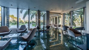 A modern indoor space with glass walls, contemporary chairs, and a polished floor. - Victoria Terme Hotel (Tivoli)