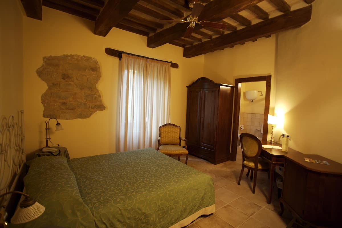 Une chambre à coucher avec un lit, une chaise, un bureau et une armoire.