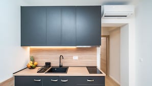 Una cocina moderna con armarios oscuros, un lavamanos negro y una encimera de madera.