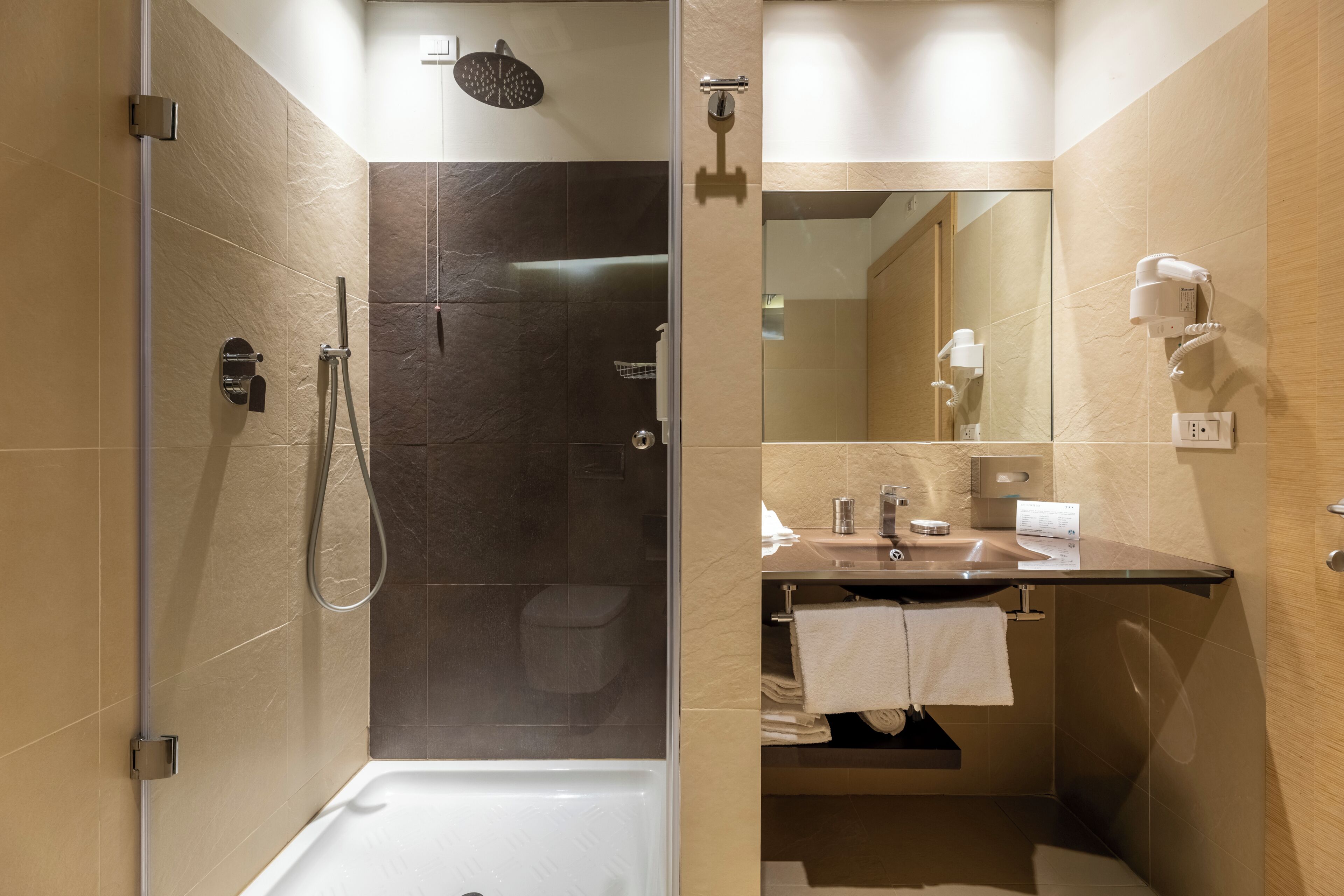 Une salle de bain moderne équipée d’une douche, de toilettes et d’un meuble-lavabo.