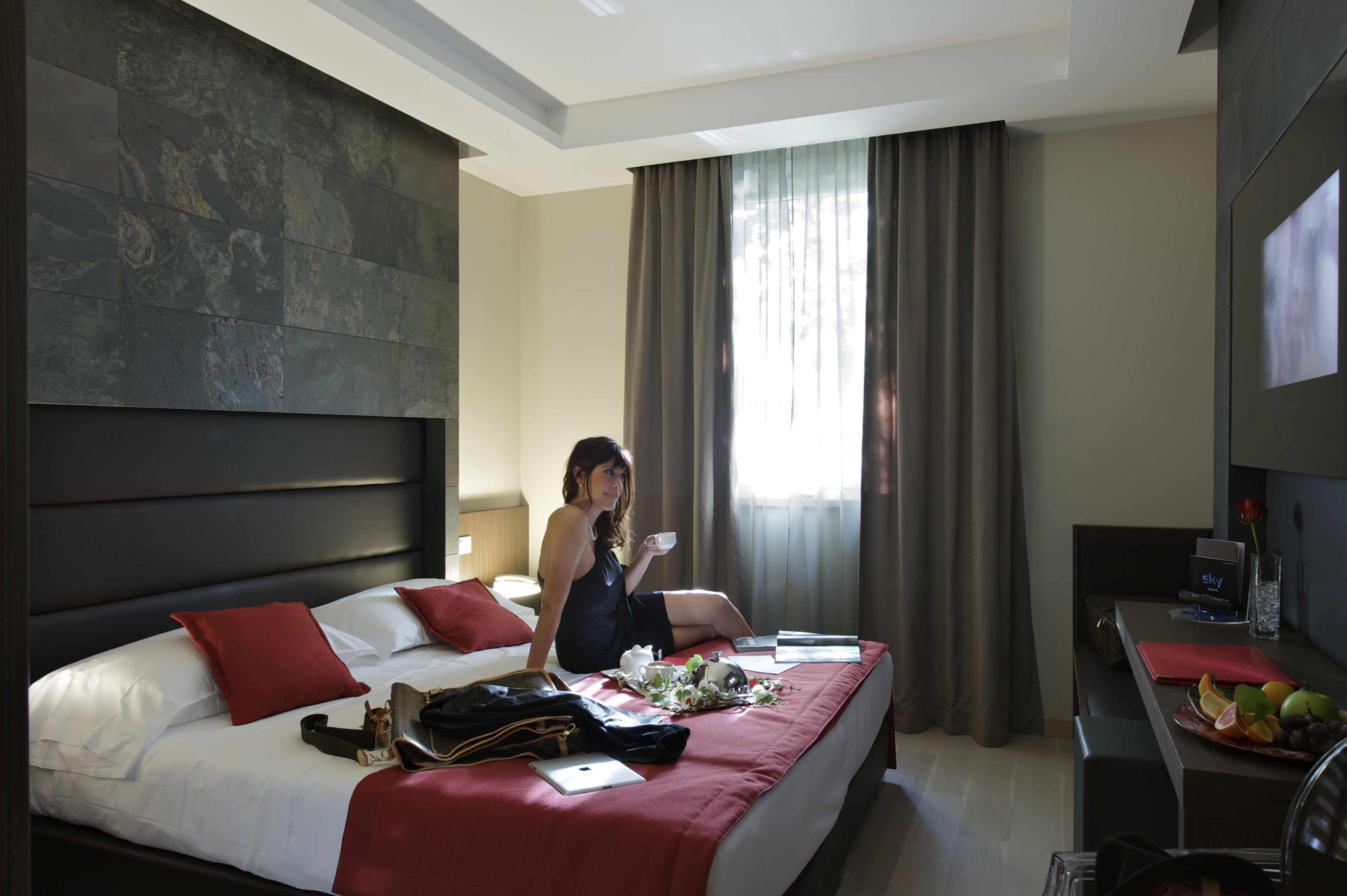 Una habitación de hotel con una cama grande, un escritorio y una televisión.