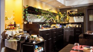 A hotel kitchen with a buffet setup, including various food items and a coffee station. - UNAHOTELS Villa dei Platani Foligno (Foligno)