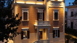 A multi-story building with a balcony, a staircase, and a well-maintained lawn. - UNAHOTELS Villa dei Platani Foligno (Foligno)