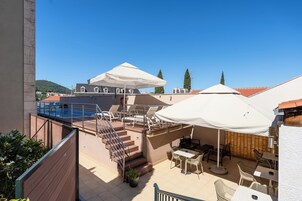 Terraço no terraço com área de estar ao ar livre, piscina e escadaria para um andar superior.